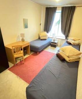 Private room with 3 beds, furniture, a large window